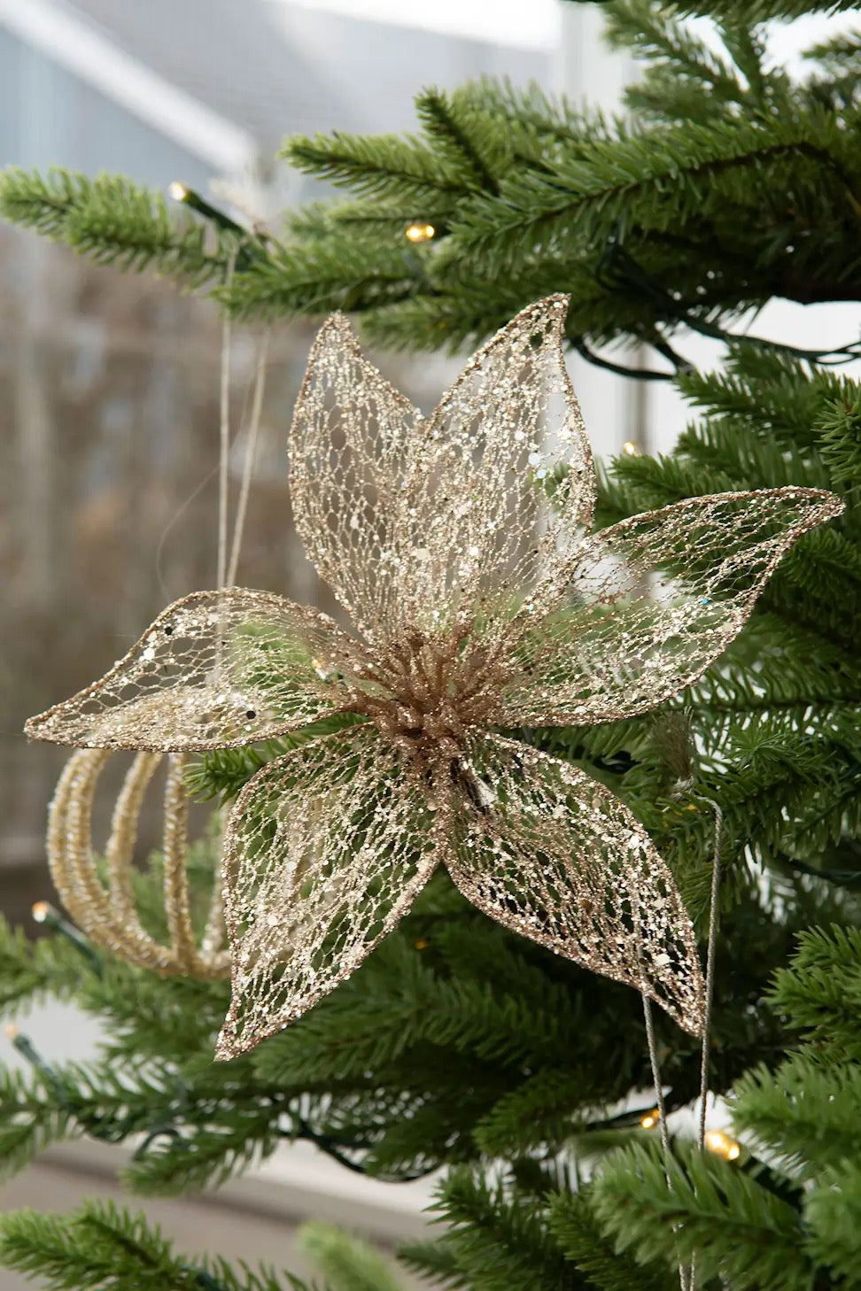 Kultaisesta läpinäkyvästä kankaasta valmistettu kaunis kukka, metalliklipsillä