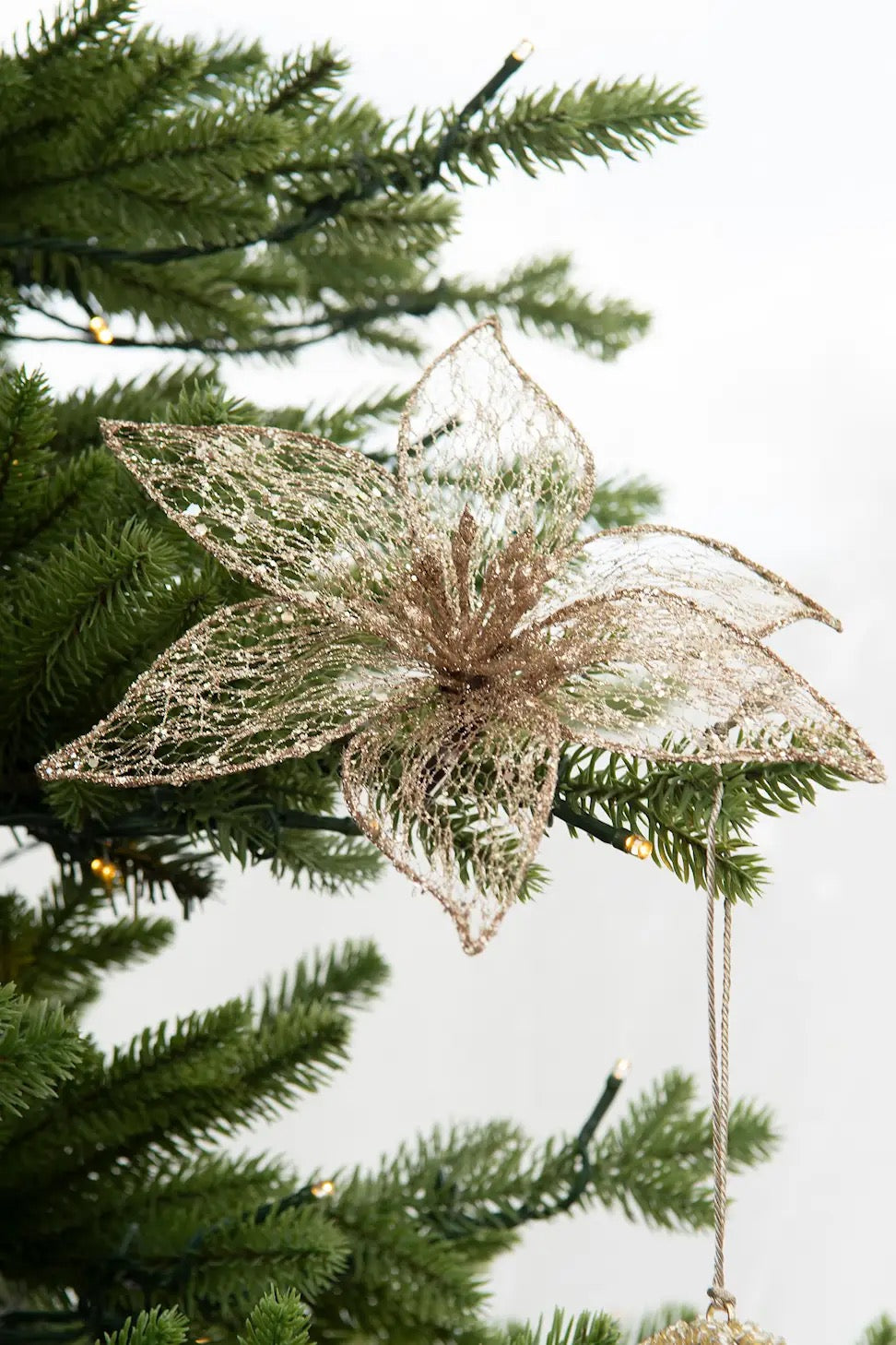 Kultaisesta läpinäkyvästä kankaasta valmistettu kaunis kukka, metalliklipsillä